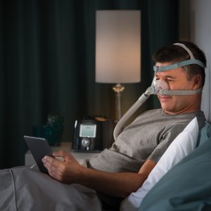 Male Reading with CPAP Machine