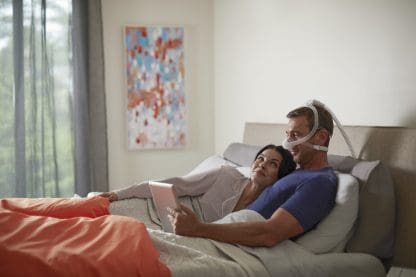 Man Reading in Bed with CPAP Nasal Mask